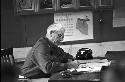 Man sitting at desk filling out form