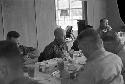 Portrait of men at large dinner table having dinner