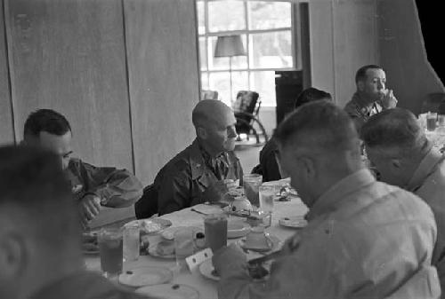 Portrait of men at large dinner table having dinner