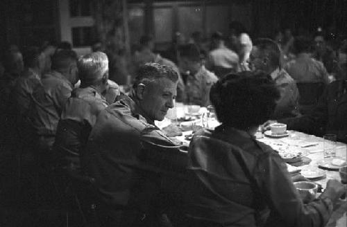 Man and woman sitting side by side conversing at dinner table