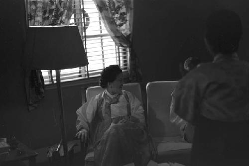 Portrait of woman dressed in gown sitting on couch