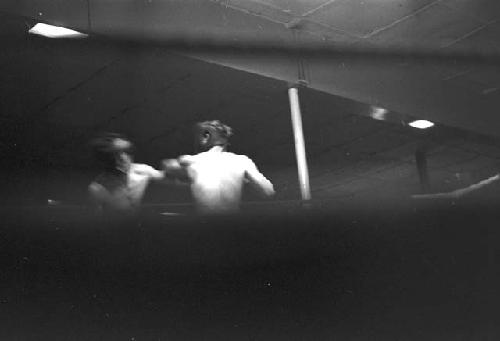 Portrait of boxers fighting in ring from ropes