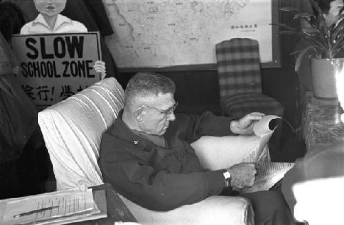 Portrait of general sitting in chair going over documents