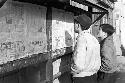 Boys on street reading page from newspaper