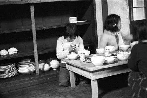 Portrait of child praying at dinner table before meal