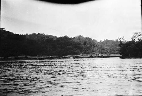 Raised Huts over river with docks and a boat