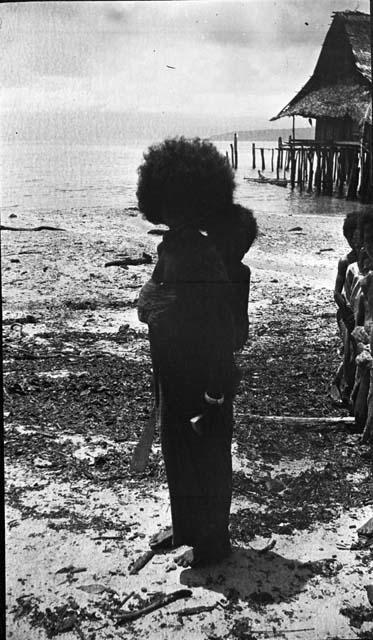 Woman standing on beach with child