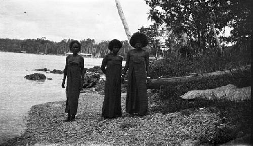 Three women standing on the beach