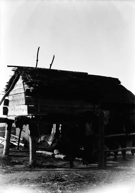 Wooden house on stilts with people in front