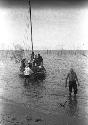 Boat anchored in shallow water near sandy shore