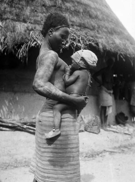 Woman breast feeding infant wearing cap