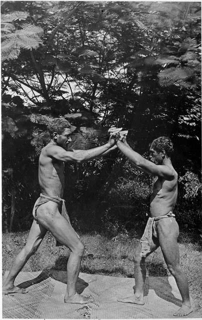 Two men hand wrestling on mat, 1889