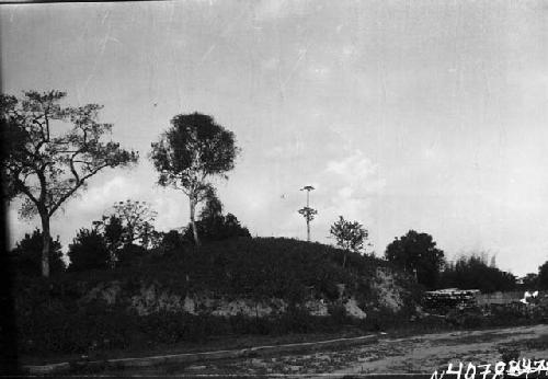 Earthen mound next to structure and road