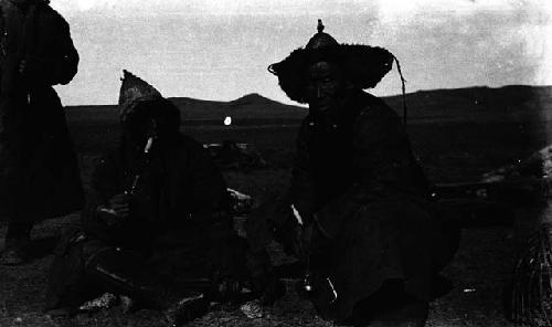 Two men seated and smoking