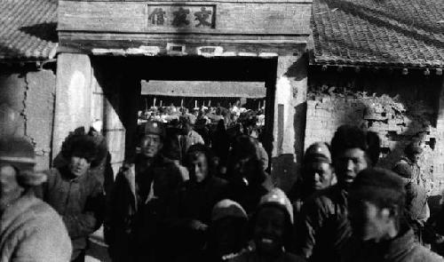 Crowd of people by gate in wall