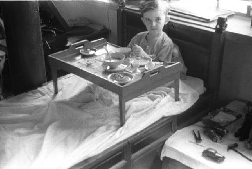 David Lattimore sitting in bed with tray of food in front of him