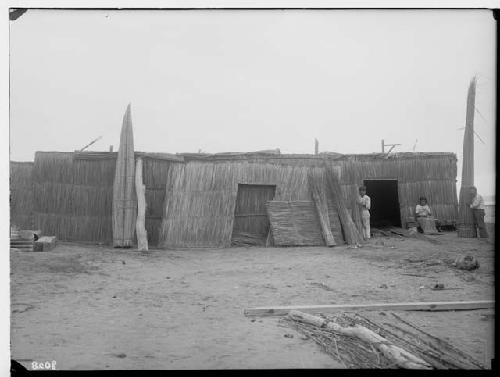 Fisherman's hut. Father and son holding Cabillitos, daughter mending net