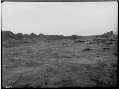 Part of some walls in square of Tello group. Background and foreground are remains of dwellings.