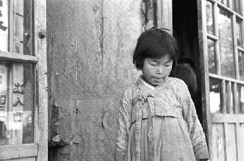 Portrait of girl looking down leaning against wall