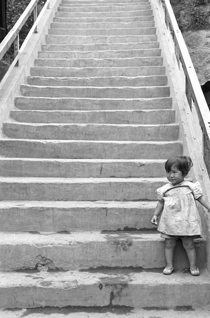 Girl holding onto hand rail on steps