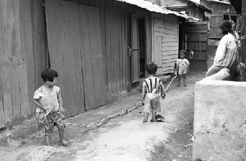 Portrait of three children playing with long rope