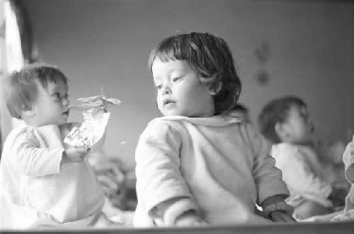 Portrait of baby in white garment face turned toward window