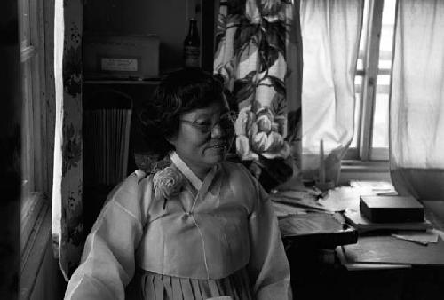 Portrait of woman standing by window happy