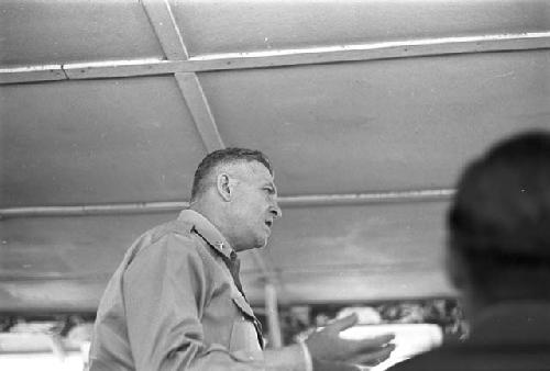 Soldier addressing men in room