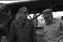 Soldiers conversating outside in front plane
