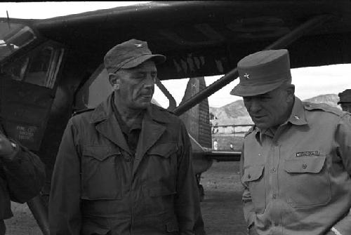 Soldiers conversating outside in front plane