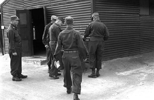 Soldiers walking towards object outside building