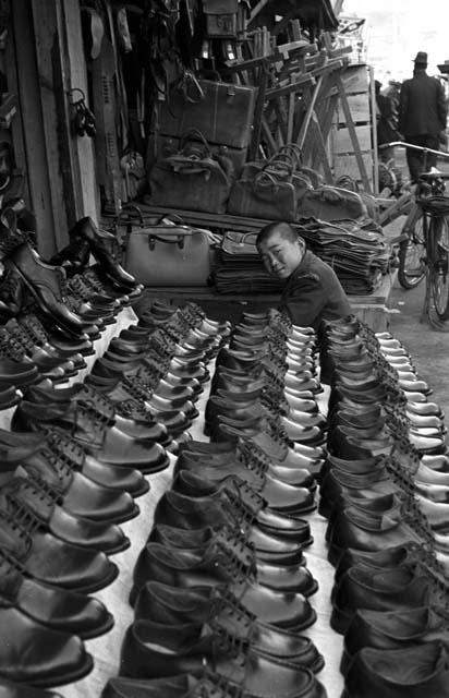 Boy sitting by shoe stand