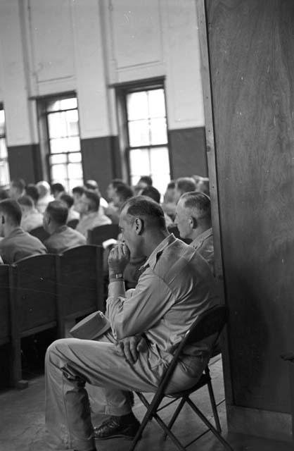 Men sitting in rear of auditorium