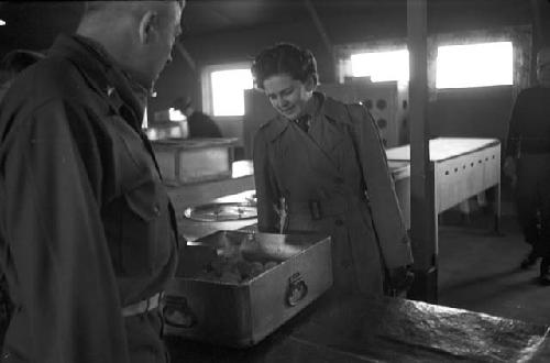 Soldiers observing food in box at table