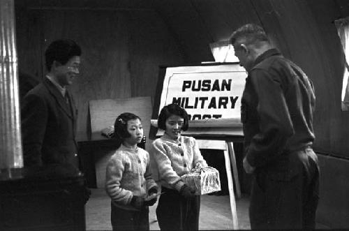 General Richard Whitcomb goodwill mission visit with two young girls from Greenhill Orphanage, presenting him with a box of eggs.