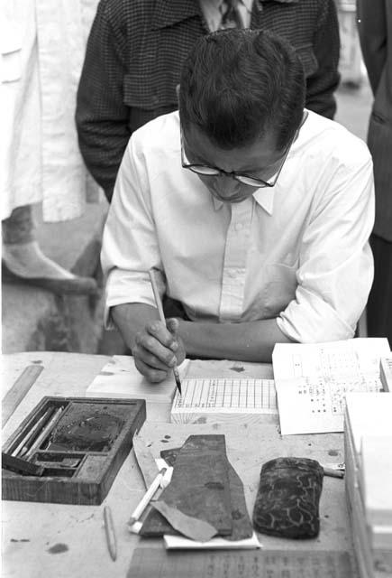 Man carving out wood writing