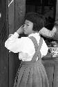 Little girl in dress pressing against wall