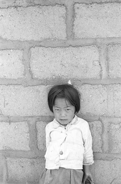 Portrait of girl outside leaning back against wall