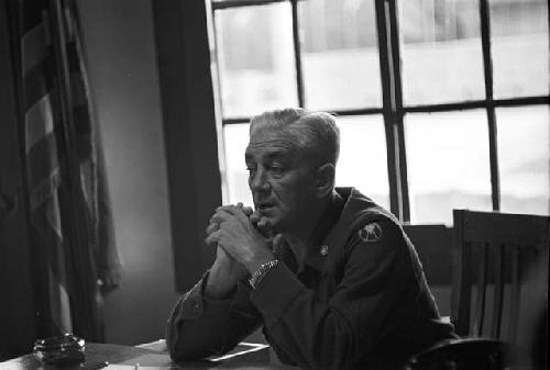 Portrait of soldier sitting at desk hands folded