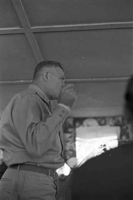 Soldier addressing men in room