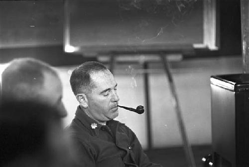 Portrait of man sitting with eyes closed smoking pipe