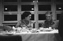 Man and woman sitting side by side conversating at dinner table