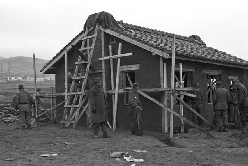 Soldiers working on house