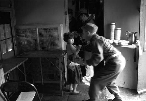 Girl being treated by soldier