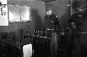 Portrait of soldier standing in front of rows of taps