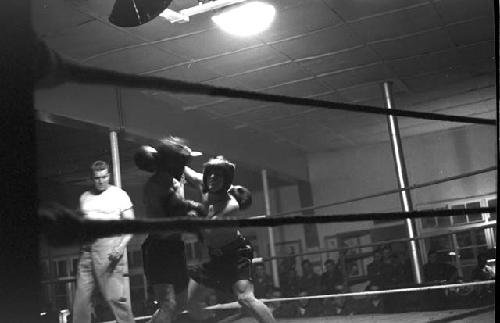 Portrait of boxers fighting in ring from ropes