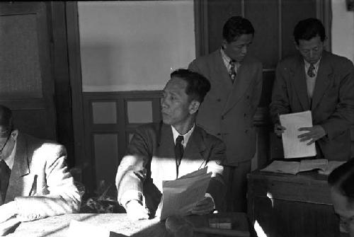 Man in suit writing notes during meeting