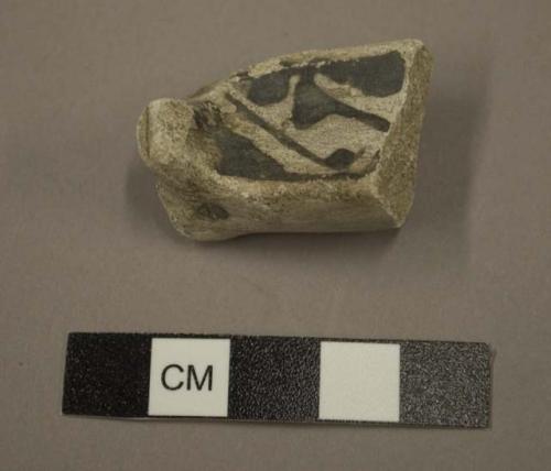 Zoomorphic black on white pottery handle fragment