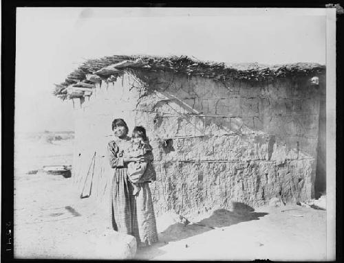 Woman and child in front of house