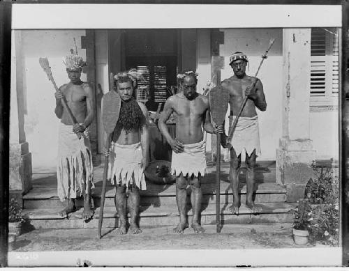 Four men with clubs and paddles